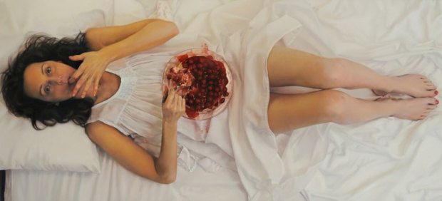 La artista Lee Price se autoretrata comiendo una tarta con cerezas en la cama