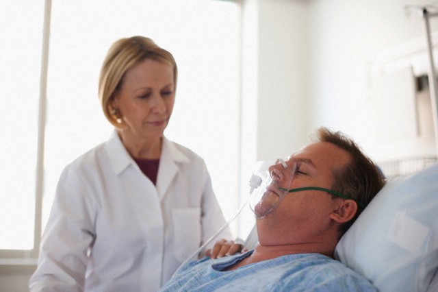 Doctor comforting patient in hospital bed